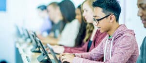 row of students typing on Microsoft Windows laptops